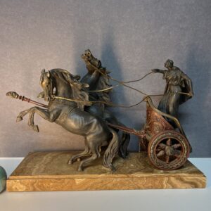 Personnage sur chariot romain tiré par des chevaux, sculpture de Carvin